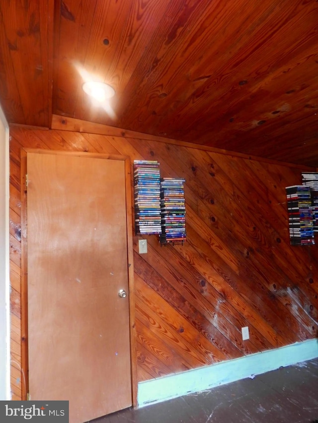 interior space featuring wooden ceiling and wooden walls