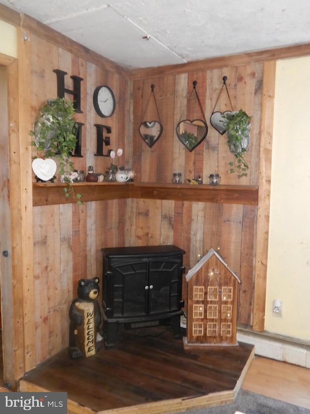 interior details with a wood stove, wood walls, and wood-type flooring