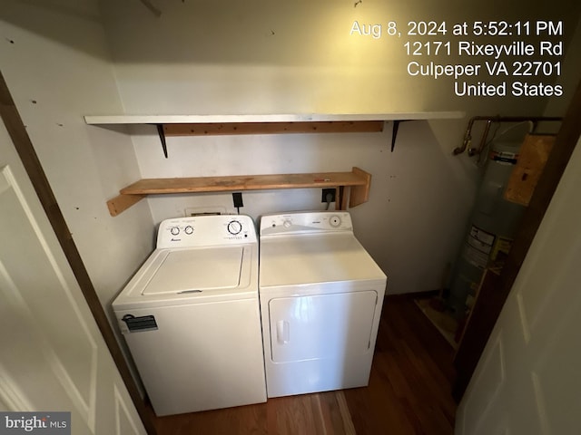 laundry room with washing machine and clothes dryer, dark hardwood / wood-style flooring, and water heater