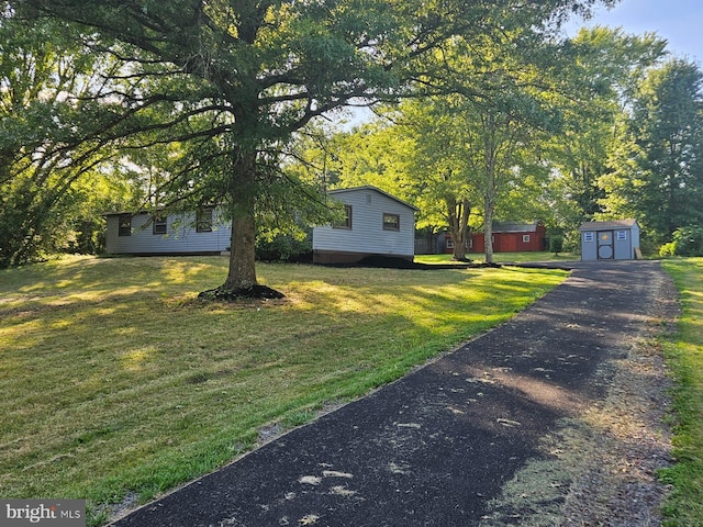 view of front of property featuring a storage unit and a front yard