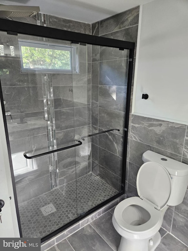 bathroom featuring toilet, tile walls, and walk in shower