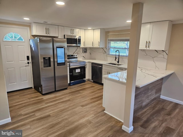 kitchen featuring white cabinetry, sink, hardwood / wood-style flooring, and appliances with stainless steel finishes