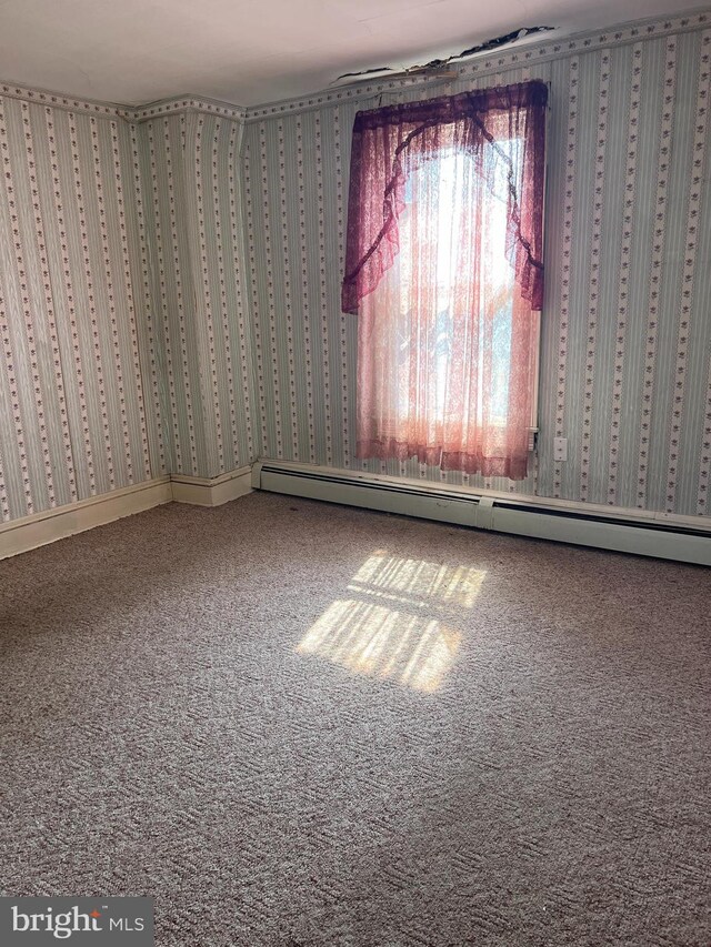 empty room with carpet and baseboard heating