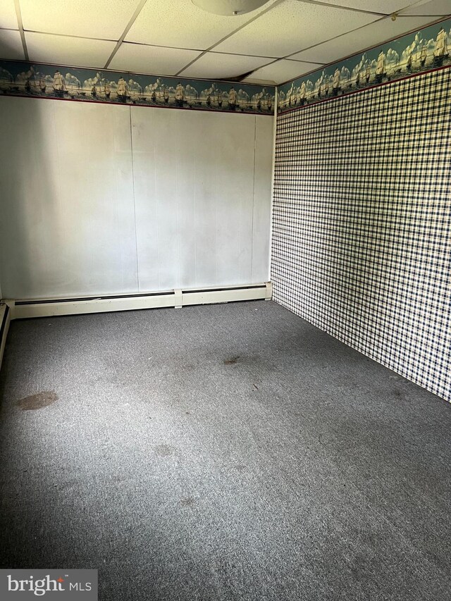 unfurnished room with carpet floors and a drop ceiling