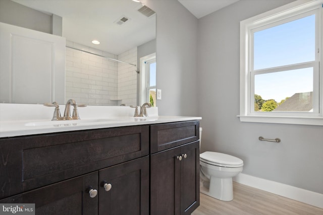 bathroom featuring walk in shower, hardwood / wood-style floors, vanity, and toilet