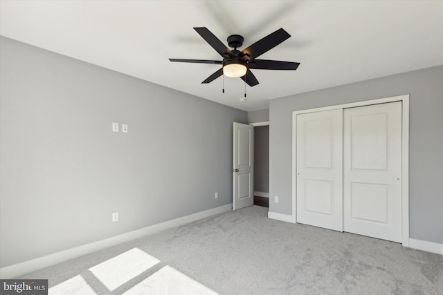 unfurnished bedroom with ceiling fan, light colored carpet, and a closet