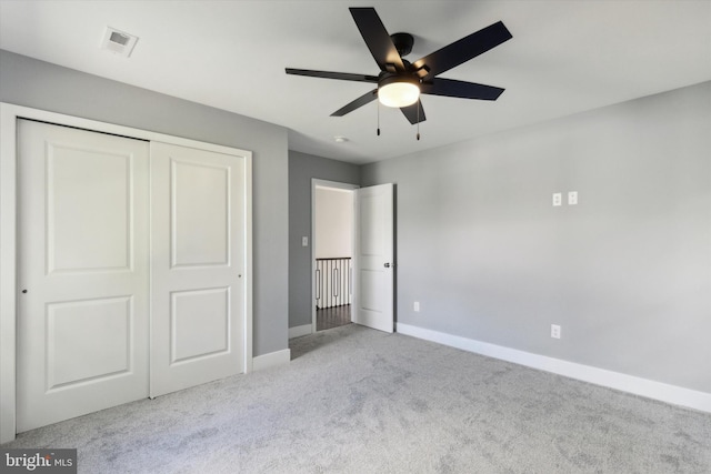 unfurnished bedroom with light colored carpet, a closet, and ceiling fan