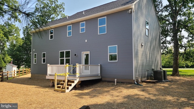 rear view of house with a wooden deck and cooling unit