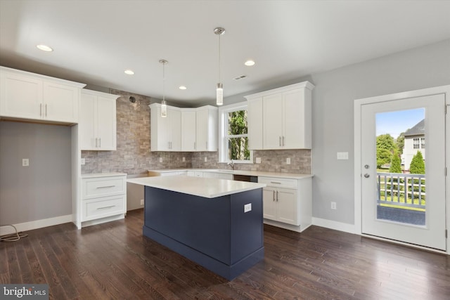 kitchen with a kitchen island, dark hardwood / wood-style floors, decorative light fixtures, white cabinets, and backsplash