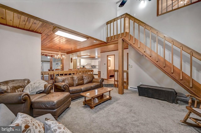 living room with a chandelier, a high ceiling, carpet floors, a baseboard radiator, and wooden ceiling