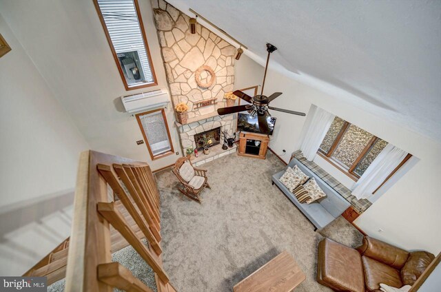 carpeted living room featuring a fireplace, ceiling fan, high vaulted ceiling, and a wall unit AC