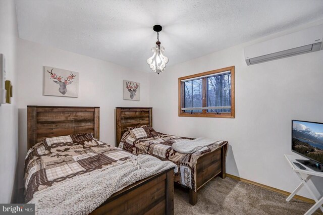 carpeted bedroom featuring a notable chandelier, a textured ceiling, and a wall unit AC