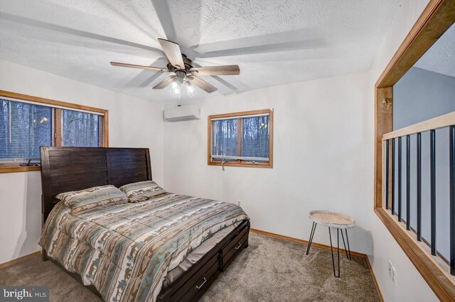 carpeted bedroom with a textured ceiling, ceiling fan, and a wall mounted AC