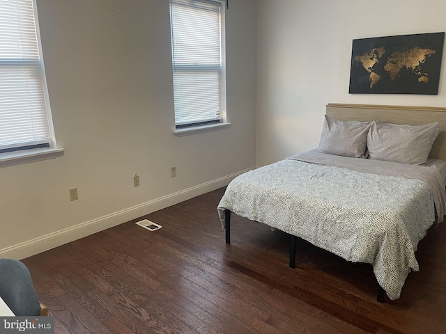 bedroom featuring wood-type flooring and multiple windows