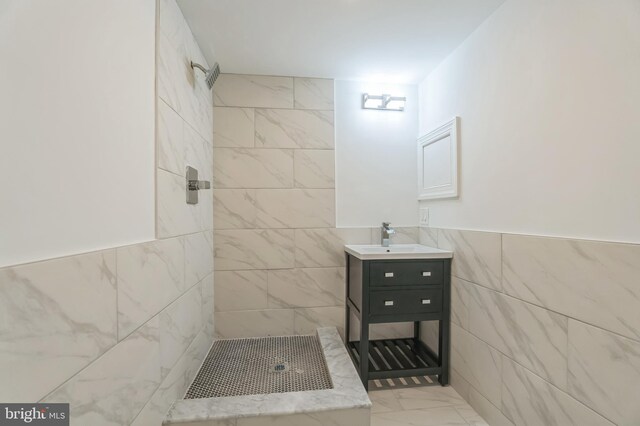 bathroom featuring vanity, tile walls, and tiled shower