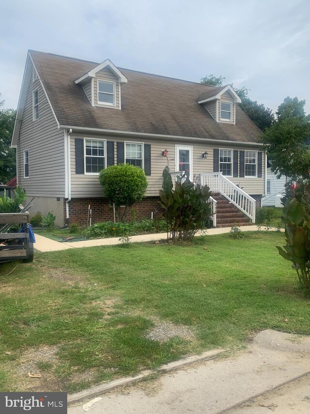 cape cod house with a front yard