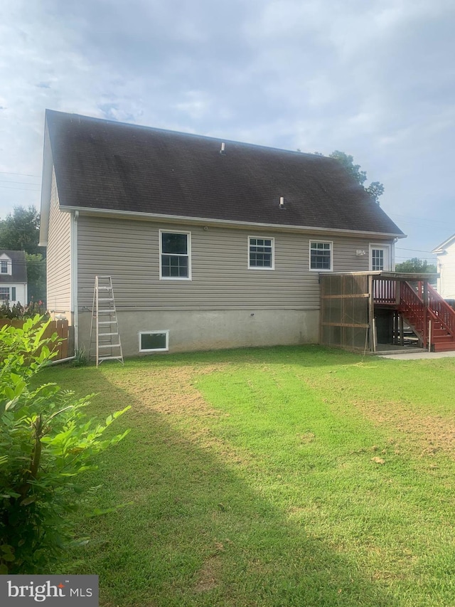 back of house featuring a wooden deck and a lawn