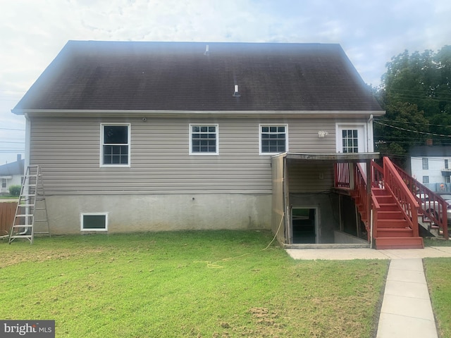 rear view of house featuring a deck and a lawn