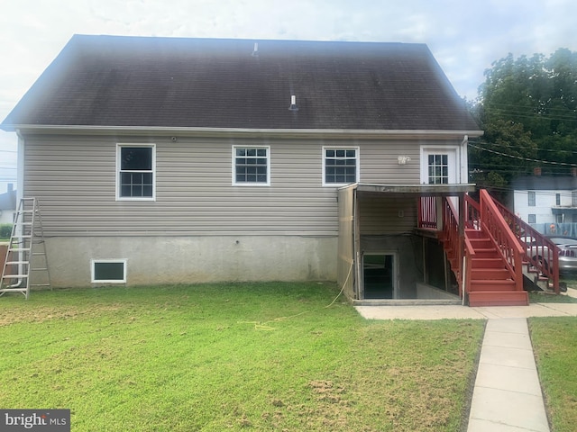 rear view of house with a deck and a yard