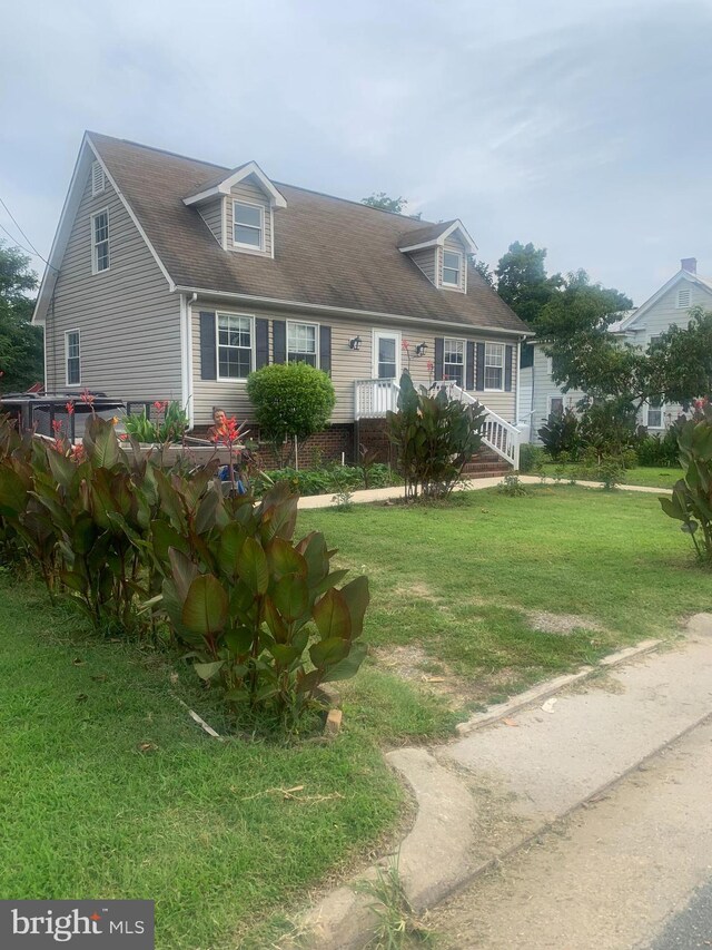 cape cod-style house featuring a front yard