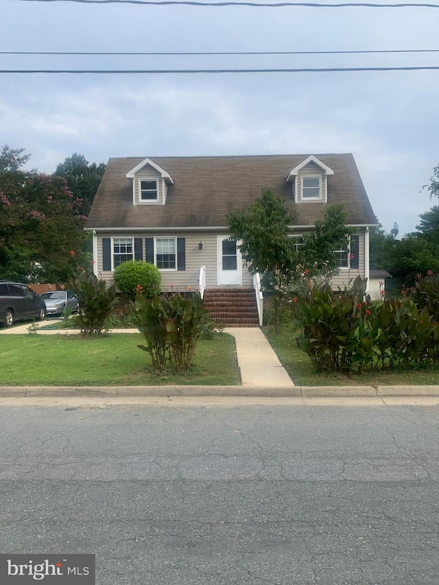 cape cod house with a front yard