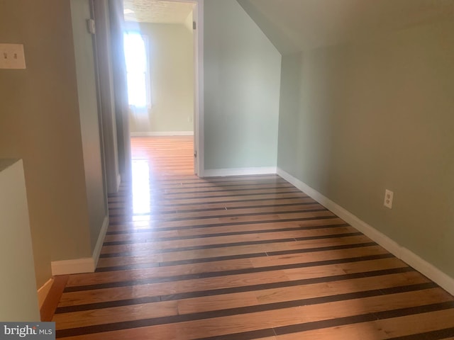 hall featuring vaulted ceiling and dark hardwood / wood-style floors