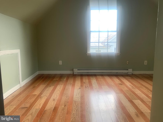 additional living space with lofted ceiling, baseboard heating, and light hardwood / wood-style flooring