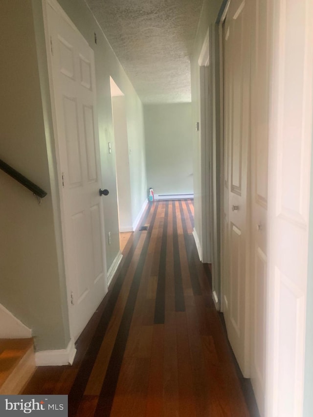 hallway featuring a textured ceiling and dark wood-type flooring