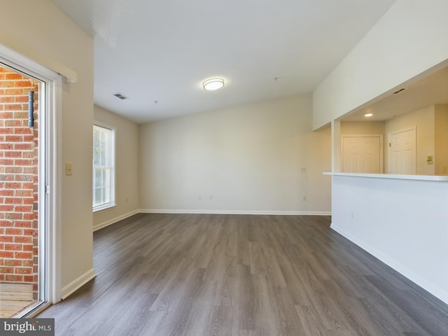 unfurnished living room featuring lofted ceiling and dark hardwood / wood-style floors