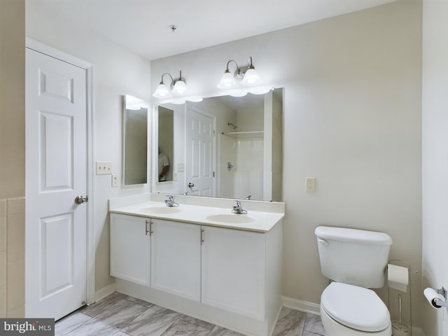 bathroom with walk in shower, vanity, and toilet