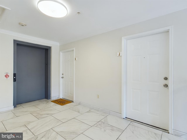 entrance foyer featuring elevator and ornamental molding