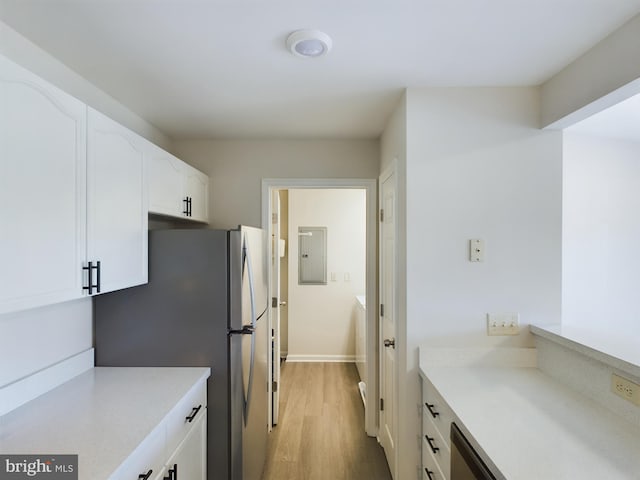 kitchen featuring electric panel, stainless steel fridge, light wood-type flooring, and white cabinetry