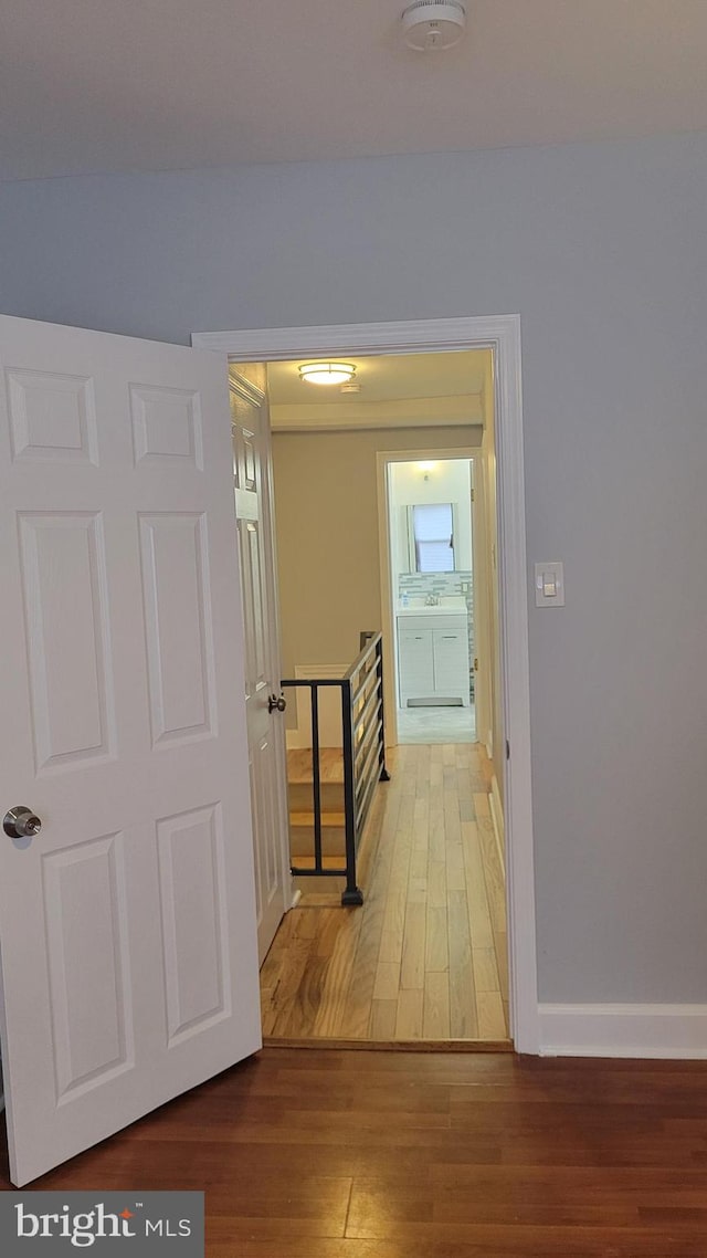 corridor with hardwood / wood-style floors