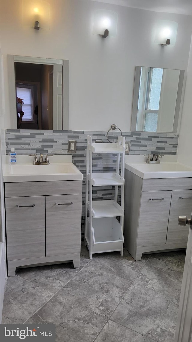 bathroom featuring a healthy amount of sunlight, tasteful backsplash, vanity, and tile patterned floors