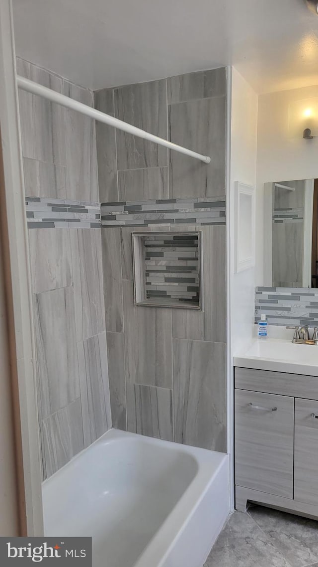 bathroom featuring tiled shower / bath, tile patterned floors, and vanity