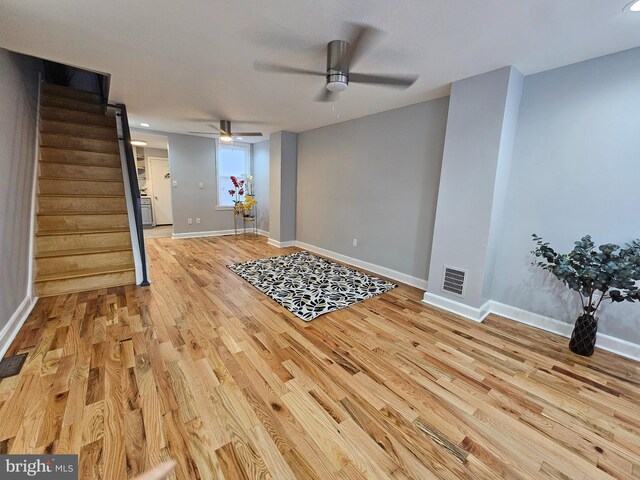 kitchen with light wood-type flooring, range with gas cooktop, and light stone countertops