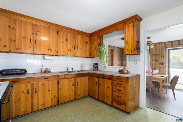 kitchen with sink, stove, tasteful backsplash, and ceiling fan