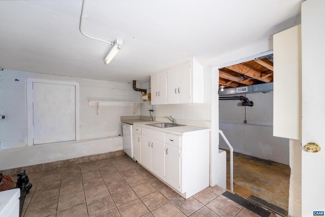 interior space featuring white dishwasher, sink, and white cabinetry