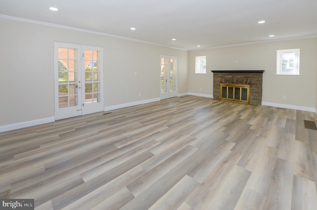 unfurnished living room featuring a wealth of natural light, light hardwood / wood-style floors, and french doors