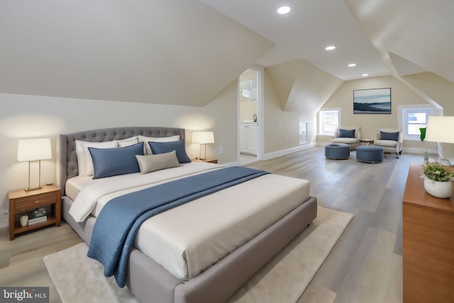 bedroom with light hardwood / wood-style floors and lofted ceiling