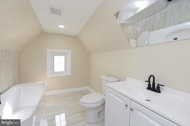 bathroom featuring a tub, vaulted ceiling, vanity, and toilet