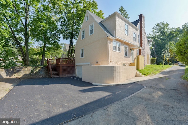 view of side of home with a deck and a garage