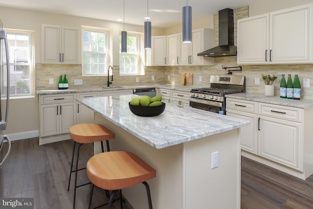 kitchen with wall chimney exhaust hood, dark hardwood / wood-style flooring, white cabinetry, a center island, and stainless steel appliances