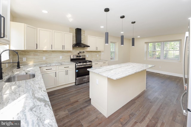 kitchen featuring backsplash, sink, dark hardwood / wood-style floors, stainless steel gas range, and wall chimney range hood