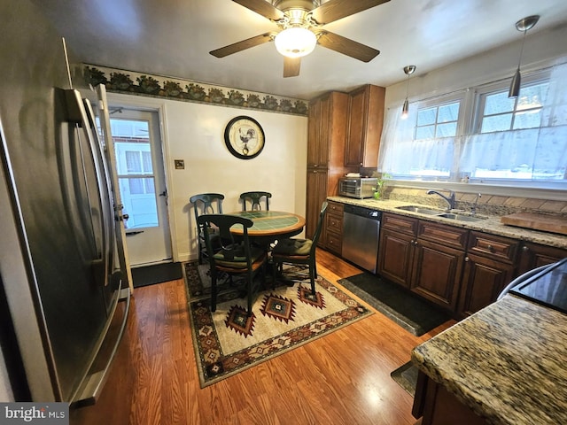 kitchen featuring decorative light fixtures, dark hardwood / wood-style flooring, sink, ceiling fan, and appliances with stainless steel finishes