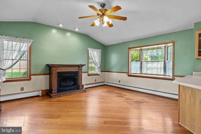 unfurnished living room featuring a baseboard radiator, a wealth of natural light, and light hardwood / wood-style floors