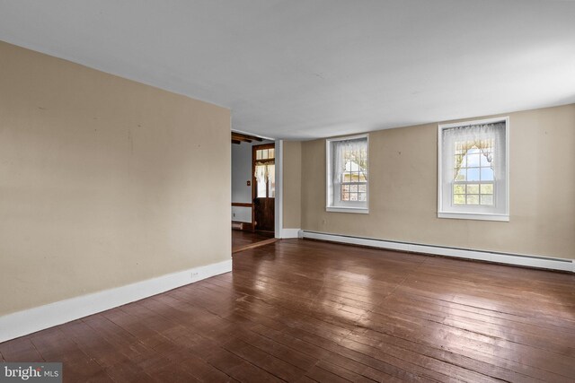 spare room featuring a baseboard radiator and wood-type flooring