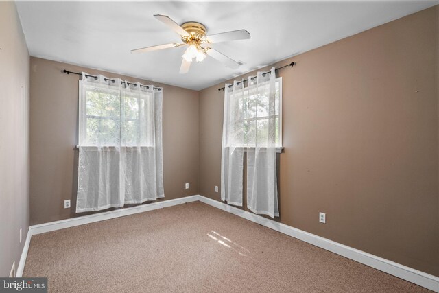 carpeted spare room featuring ceiling fan