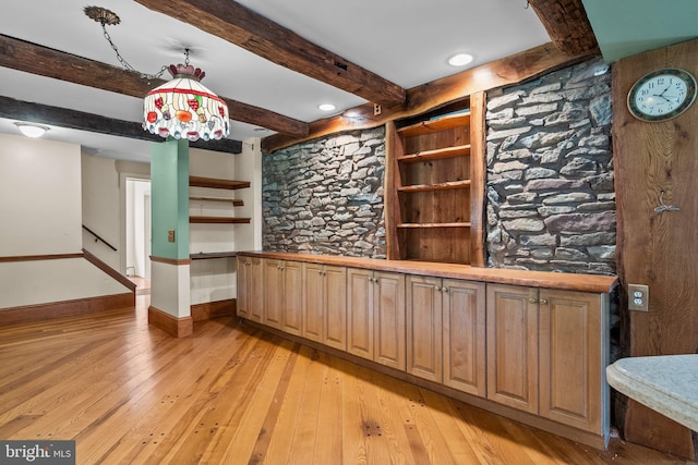 wine room featuring beamed ceiling and light wood-type flooring