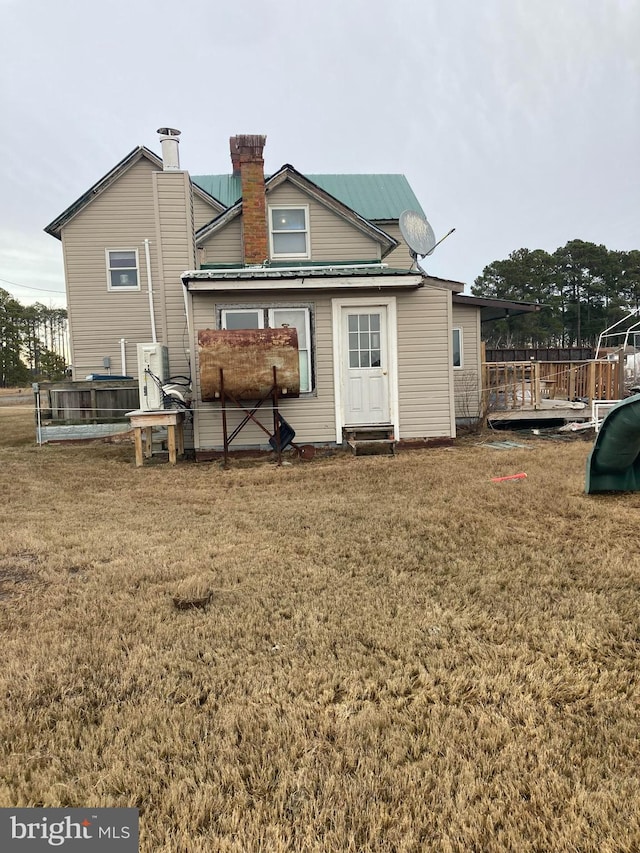 rear view of house featuring a yard and a deck